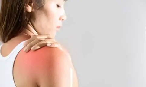 woman touching her shoulder