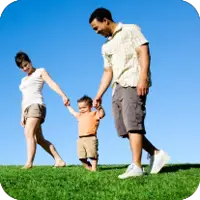 mom and dad walking with their toddler