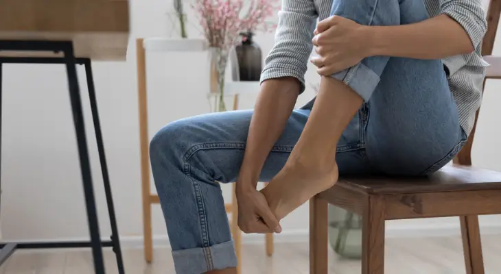 woman-holds-her-foot