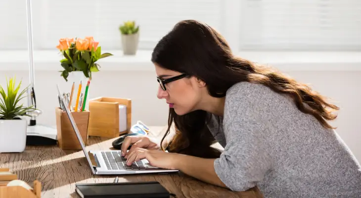 woman-leans-over-desk