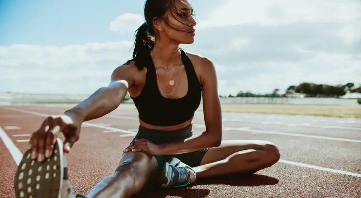 woman-stretches-on-a-track-field